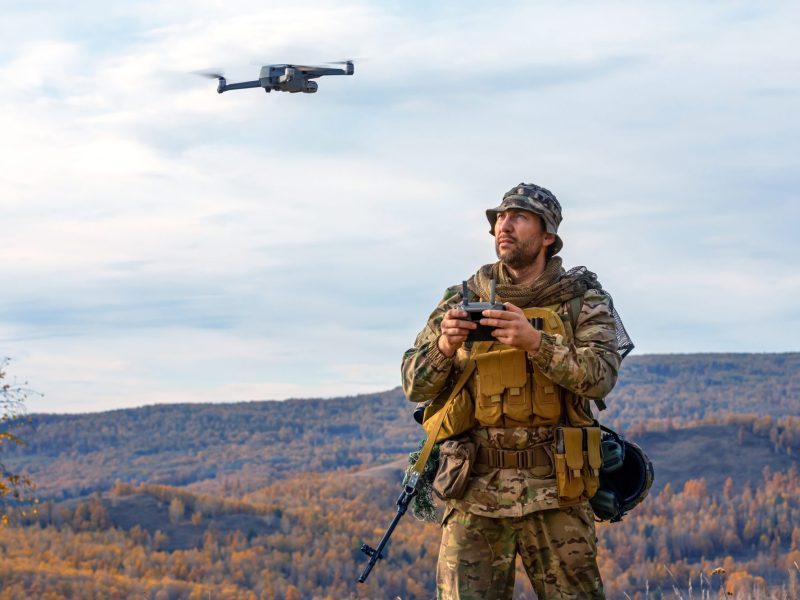 Photo of an artillery spotter or military observer launches a drone into the sky for reconnaissance in enemy territory.