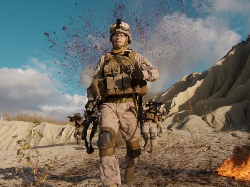 Shot of Fully Equipped Soldier Running Away From the Explosion. His Squad is Being Attacked and Bombed During Combat in the Desert.